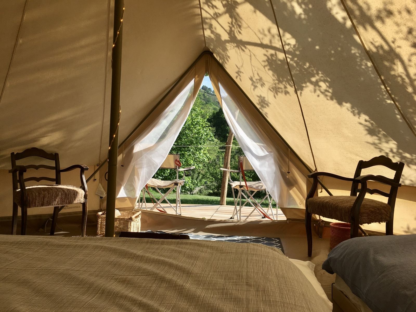 Lits et chaises dans la tente tipi ouverte sur le jardin
