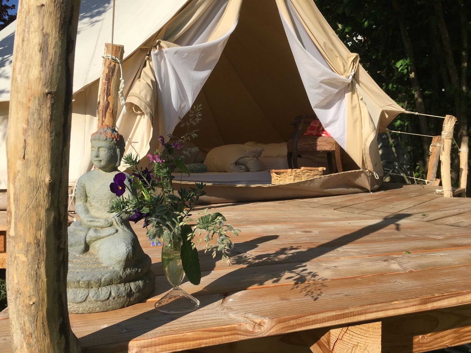 Terrasse en bois de la tente tipi avec statue et fleurs