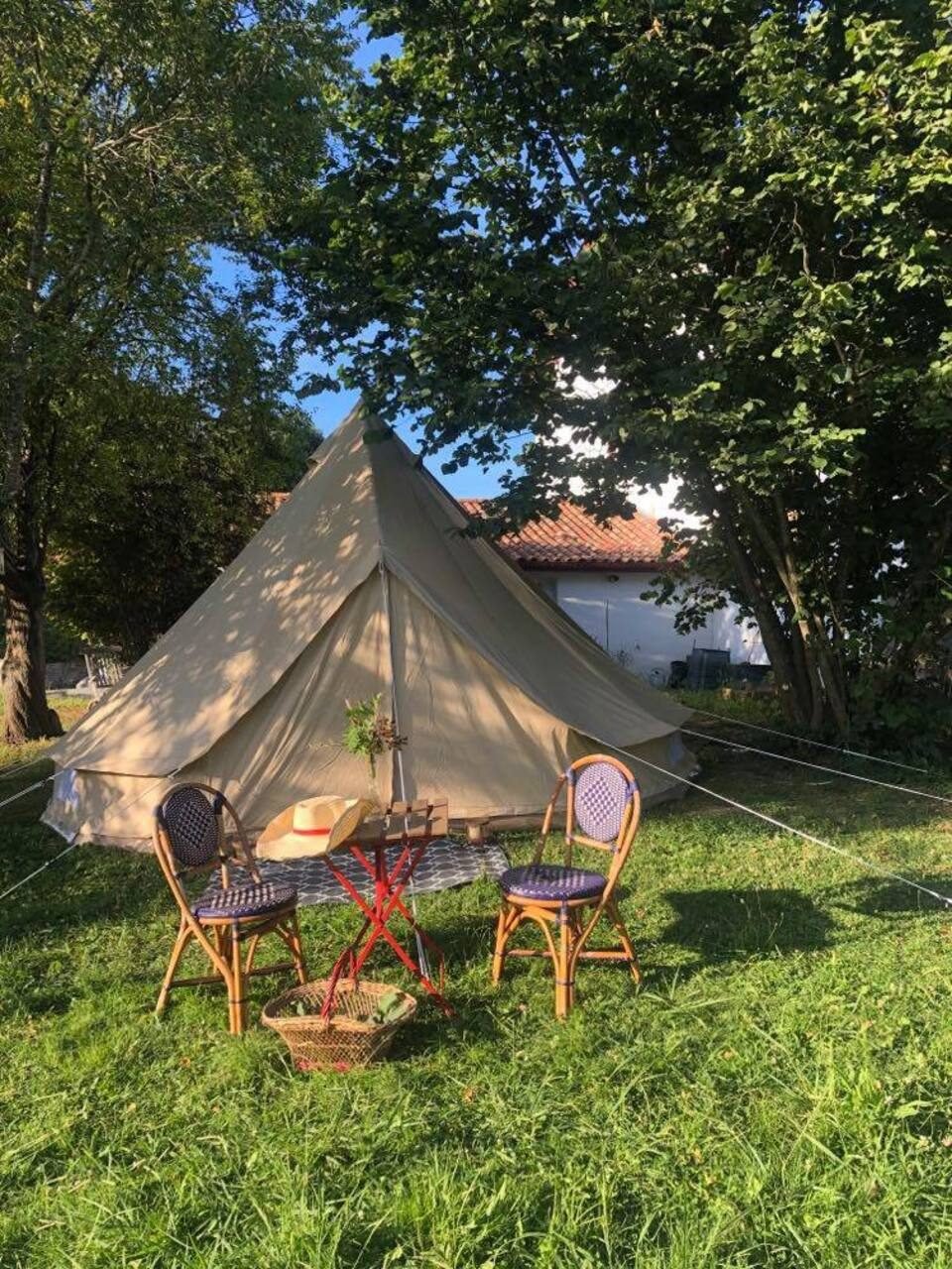 Tente tipi installée dans le jardin devant une maison basque traditionnelle à Gamarthe