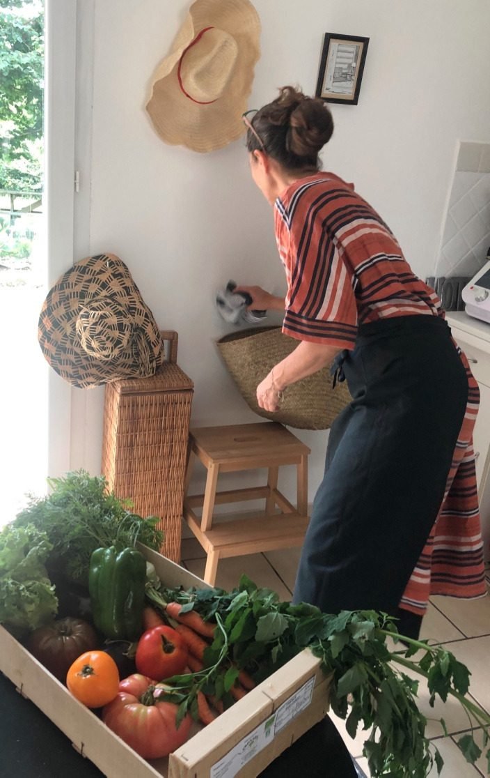 Val en cuisine avec une cagette de légumes frais